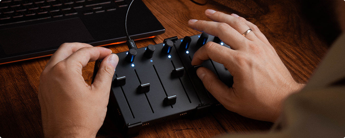 Grid on a dark wood table, man adjusting controllers